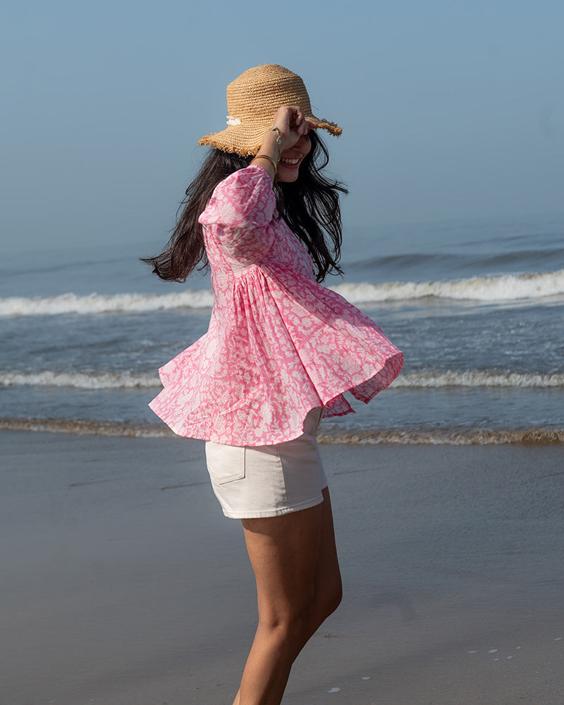 Voluminous kedia style top with a beautiful bohemian feel to it. It is a versatile top that can be worn with white pants, shorts, skirt or denims or even styled as a blouse with a saree. Even as a jacket to add a voluminous layer of style to any ensemble. Made in pink floral handblock print mal mal cotton.