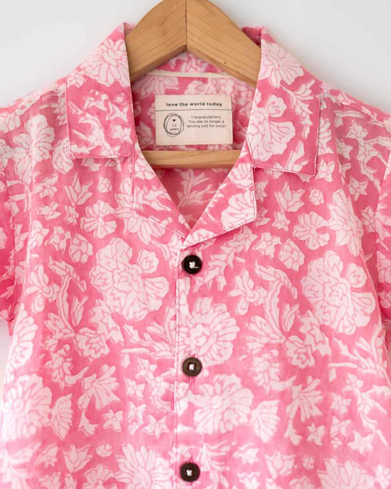 Light pink floral loose fit relaxed mul mul shirt for boys with a stylish cuban collar and natural coconut shell buttons made by handblock print artisans in Jaipur, Rajasthan.