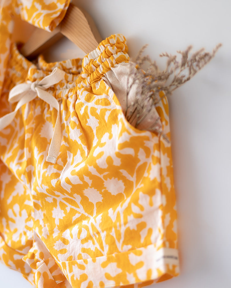 A relaxed half sleeve yellow shirt and shorts coord. Handblock printed cotton shirt made with 100% soft and breathable mal cotton.
Shorts are made with 100% cambric cotton. Soft elastication on waist along with adjustable drawstring
Handy pockets in shorts. Natural coconut shell buttons.