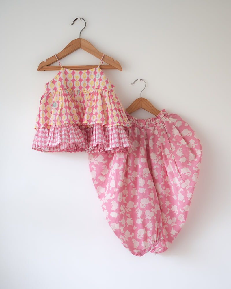 A floral baby pink hand block printed coord set. Festive spaghetti strap top with cowl dhoti pants.