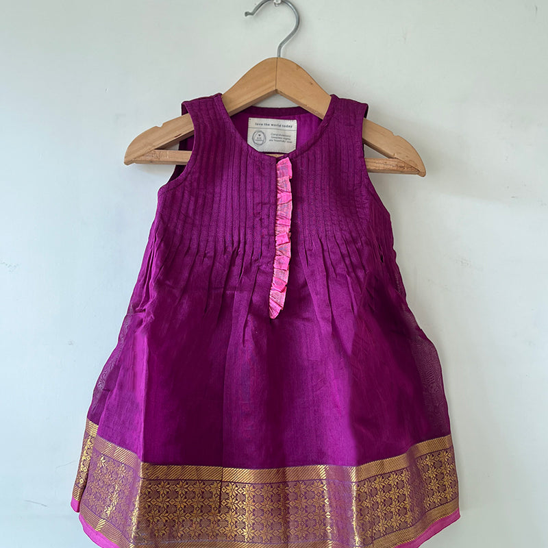 A deep purple violet sleeveless flared dress for infants in handwoven cotton silk by artisans in Maheshwar Madhya Pradesh. Perfect for festivities like Navratri, diwali, Dussehra, dushehra, bhai dooj. Infant wear. Baby ethnic wear. Silkwear for babies. Baby girl festive wear.