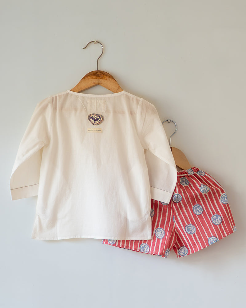 Unisex white cotton kurta and red shorts co ord set. 100% Cotton striped Shorts hand block printed by artisans in Jaipur, Rajasthan. Kurta made in GOTS certified organic cotton, has pockets and natural shell buttons.