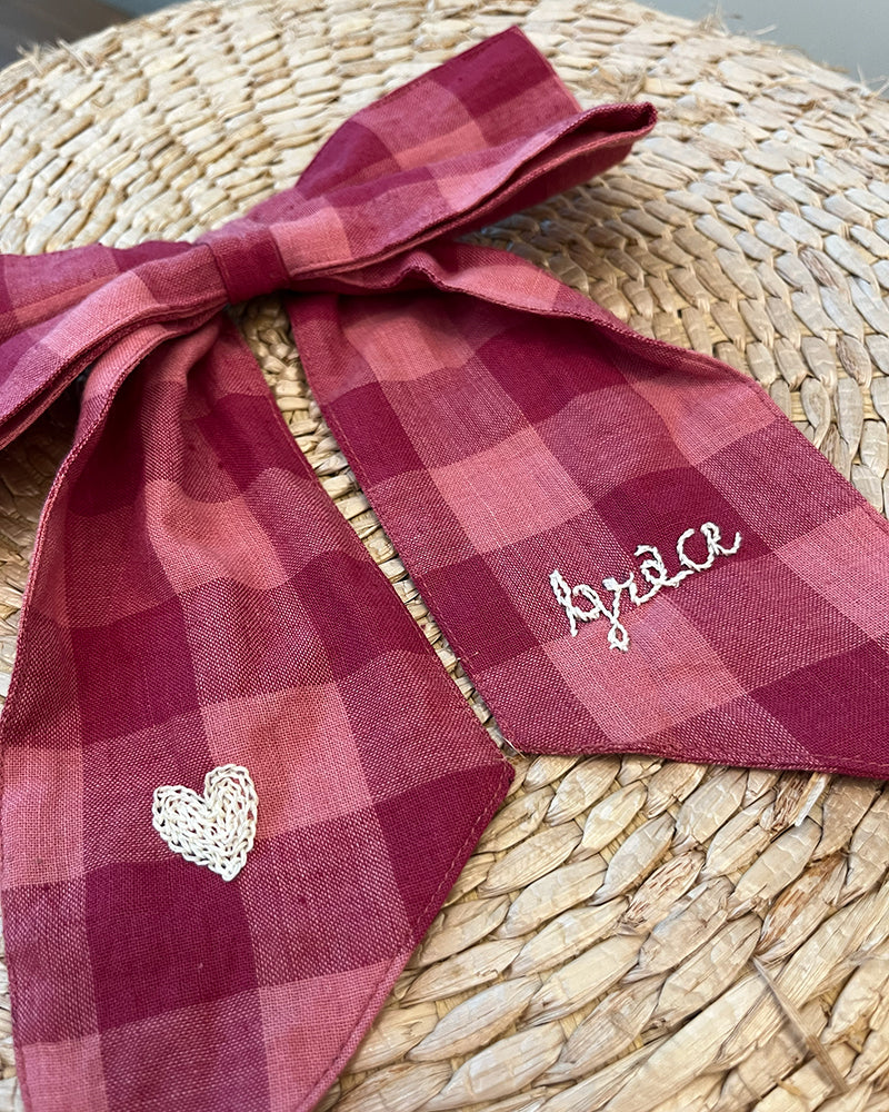 Bright pink Christmas Ornament Bow with hand embroidered affirmations.