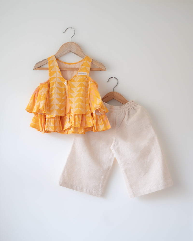 Hand block printed yellow top with solid off white pallazo pants set. Has tassels. A beautiful yellow chevron print.