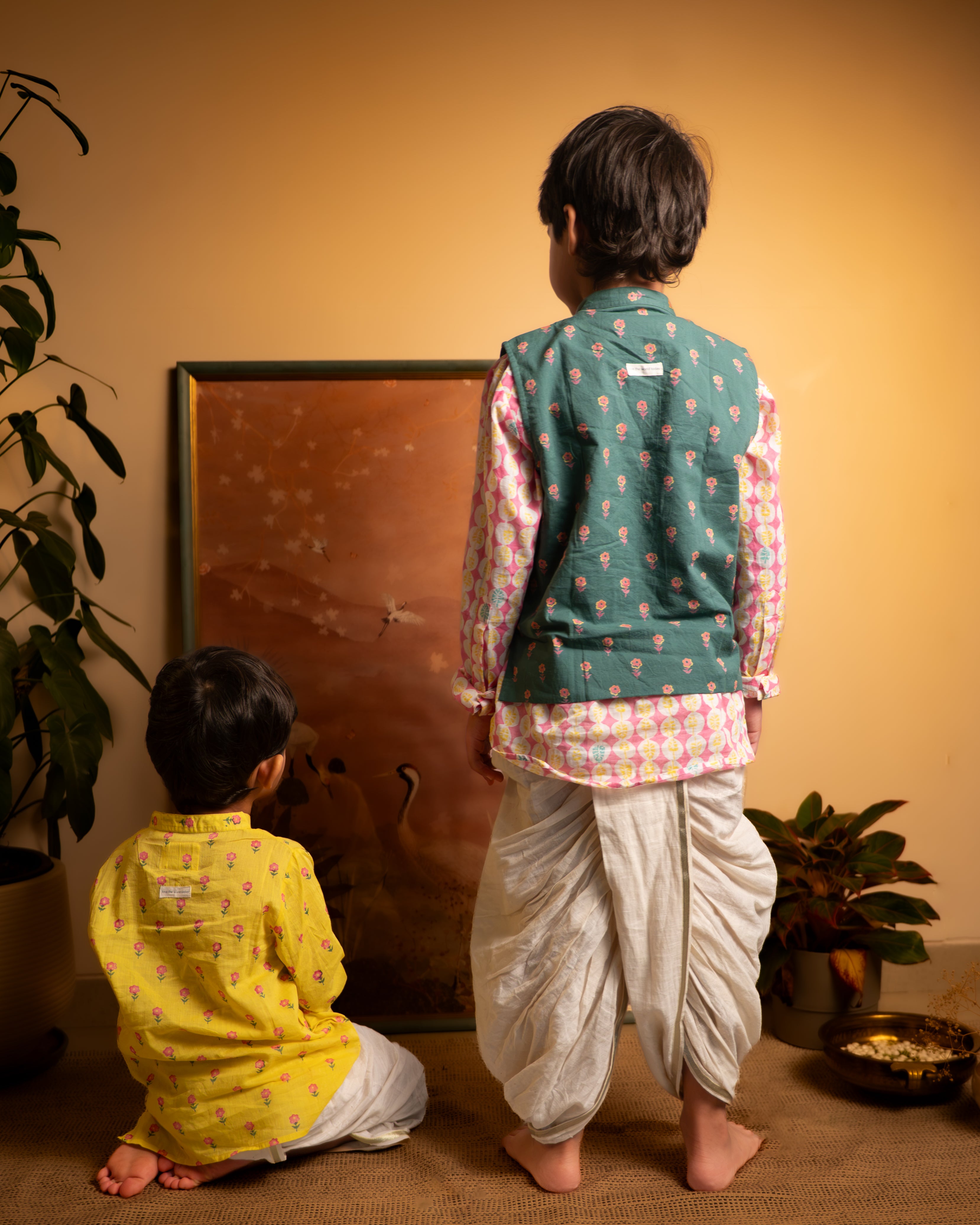 Dark green floral cotton bandi nehru jacket with self potli buttons and a golden selvedge. Paired with handwoven cotton dhoti.