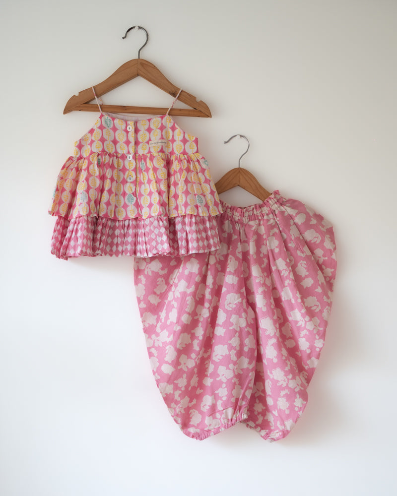 A floral baby pink hand block printed coord set. Festive spaghetti strap top with cowl dhoti pants.