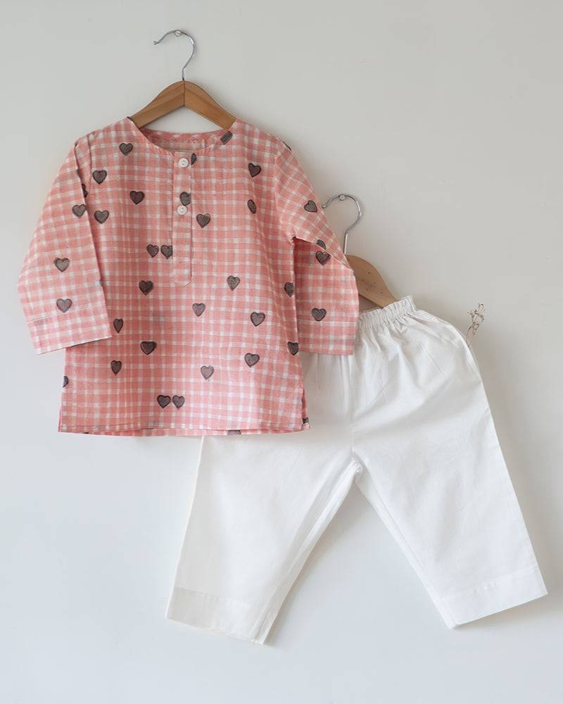 Unisex kids GOTS certified organic cotton pajama paired with peach checkered hand block printed kurta with pockets and natural shell buttons. Pajama has elastication at waist for ease of wear. Grandpa style kurta pajama set.