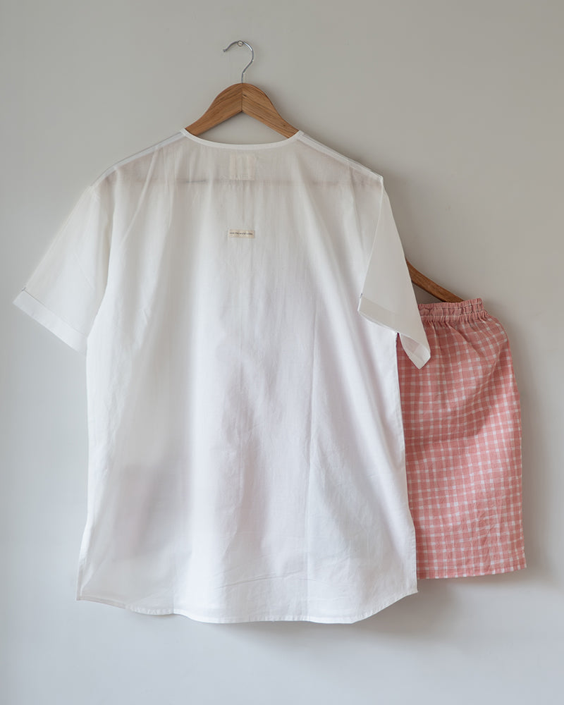 Unisex adults GOTS certified organic cotton white kurta and cotton peach shorts co ord set. 100% Cotton checkered Shorts hand block printed by artisans in Jaipur, Rajasthan. Kurta has pockets printed by hand block print. Shorts have soft elastication and drawstring at waist for ease of wear.