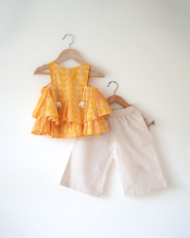 Hand block printed yellow top with solid off white pallazo pants set. Has tassels. A beautiful yellow chevron print.