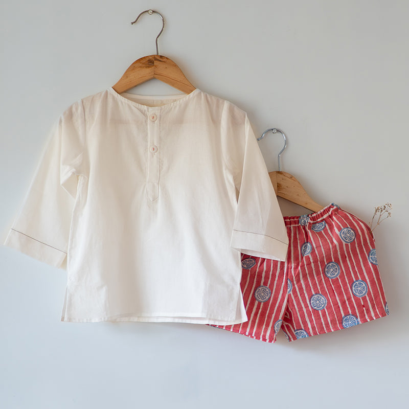Unisex white cotton kurta and red shorts co ord set. 100% Cotton striped Shorts hand block printed by artisans in Jaipur, Rajasthan. Kurta made in GOTS certified organic cotton, has pockets and natural shell buttons.