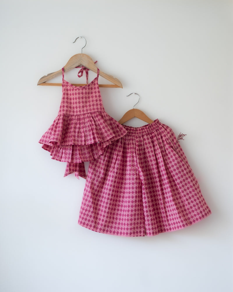 A geometric bright pink hand block printed coord set. Festive Halter neck top with pocketed pallazo pants.