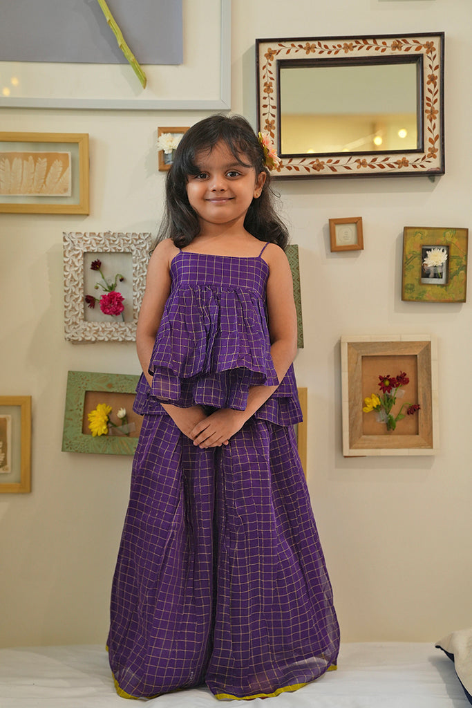 Indian girl in purple lehenga choli set smiling for the photo. 