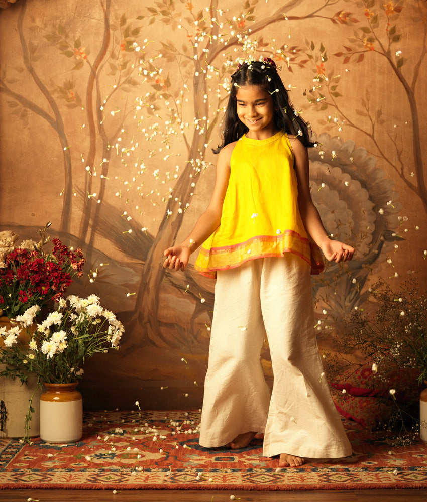 Yellow halter neck top and off white palazzo set. Made with handwoven cotton silk. Premium ethnic silk wear for kids.