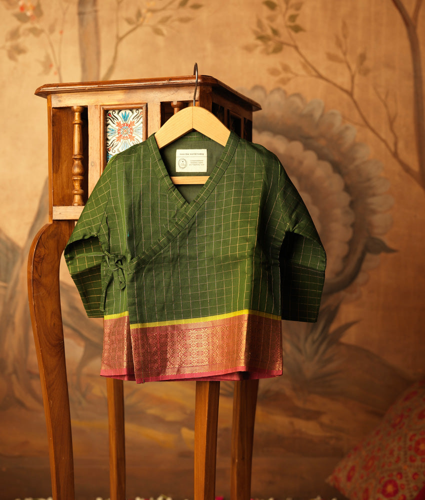 Green handwoven cotton silk infant Angrakha Kurta with traditional gold checks and a pink-gold woven border, festive ethnic wear for babies by Love The World Today. Has tie ups on side.