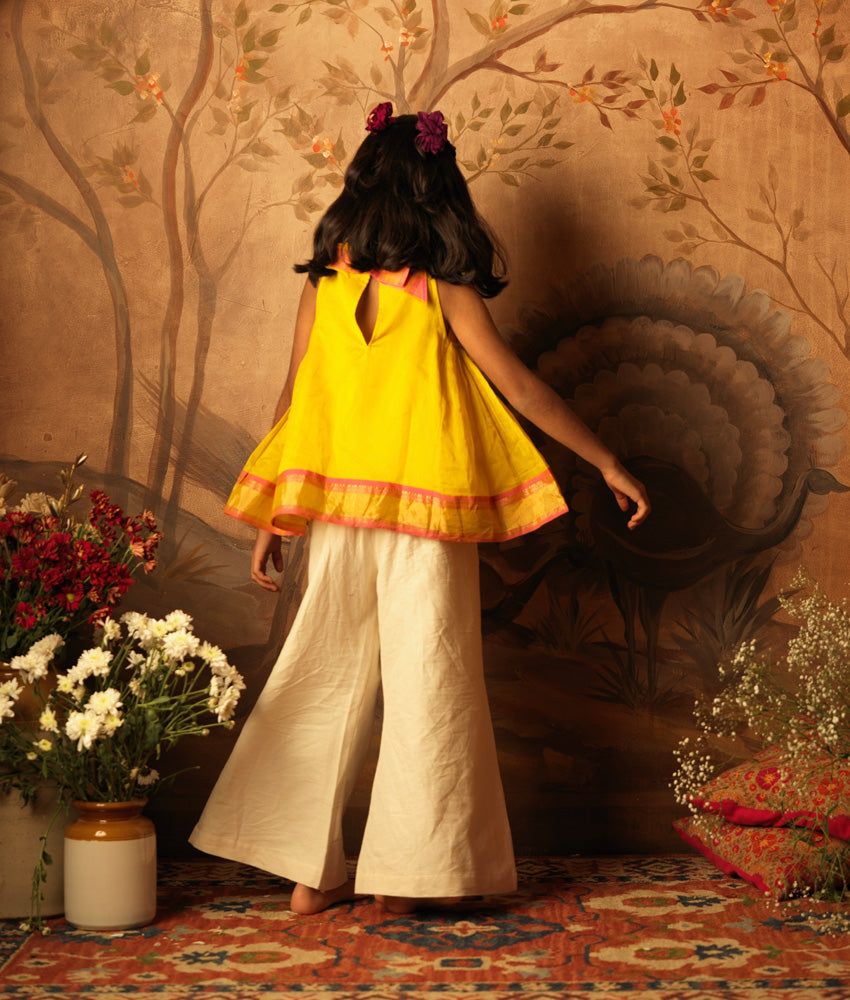 Yellow halter neck top and off white palazzo set. Made with handwoven cotton silk. Premium ethnic silk wear for kids.