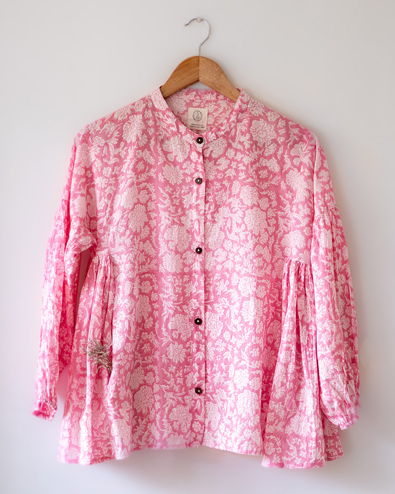 Voluminous kedia style top with a beautiful bohemian feel to it. It is a versatile top that can be worn with white pants, shorts, skirt or denims or even styled as a blouse with a saree. Even as a jacket to add a voluminous layer of style to any ensemble. Made in pink floral handblock print mal mal cotton. 