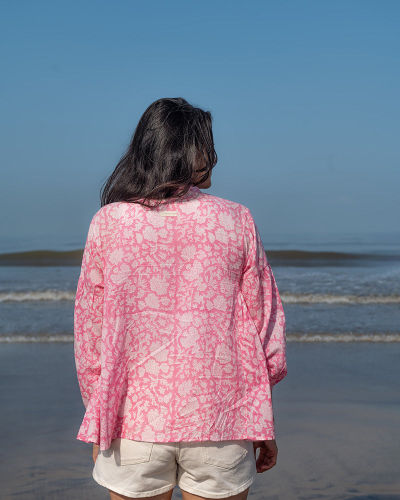 Voluminous kedia style top with a beautiful bohemian feel to it. It is a versatile top that can be worn with white pants, shorts, skirt or denims or even styled as a blouse with a saree. Even as a jacket to add a voluminous layer of style to any ensemble. Made in pink floral handblock print mal mal cotton. 