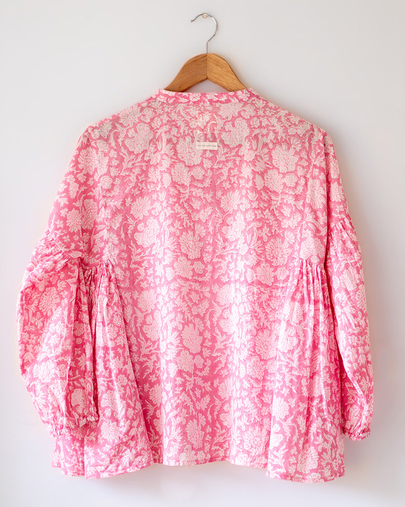 Voluminous kedia style top with a beautiful bohemian feel to it. It is a versatile top that can be worn with white pants, shorts, skirt or denims or even styled as a blouse with a saree. Even as a jacket to add a voluminous layer of style to any ensemble. Made in pink floral handblock print mal mal cotton. 