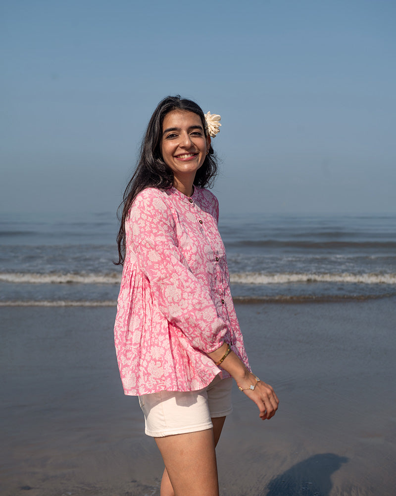 Voluminous kedia style top with a beautiful bohemian feel to it. It is a versatile top that can be worn with white pants, shorts, skirt or denims or even styled as a blouse with a saree. Even as a jacket to add a voluminous layer of style to any ensemble. Made in pink floral handblock print mal mal cotton. 