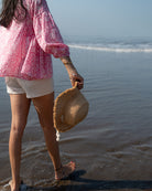 Voluminous kedia style top with a beautiful bohemian feel to it. It is a versatile top that can be worn with white pants, shorts, skirt or denims or even styled as a blouse with a saree. Even as a jacket to add a voluminous layer of style to any ensemble. Made in pink floral handblock print mal mal cotton. 