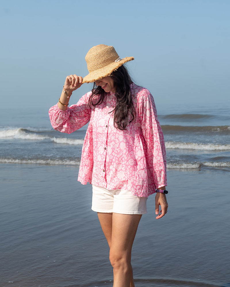 Voluminous kedia style top with a beautiful bohemian feel to it. It is a versatile top that can be worn with white pants, shorts, skirt or denims or even styled as a blouse with a saree. Even as a jacket to add a voluminous layer of style to any ensemble. Made in pink floral handblock print mal mal cotton. 