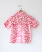 Light pink floral loose fit relaxed mul mul shirt for boys with a stylish cuban collar and natural coconut shell buttons made by handblock print artisans in Jaipur, Rajasthan.