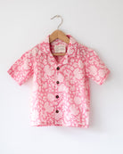 Light pink floral loose fit relaxed mul mul shirt for boys with a stylish cuban collar and natural coconut shell buttons made by handblock print artisans in Jaipur, Rajasthan.