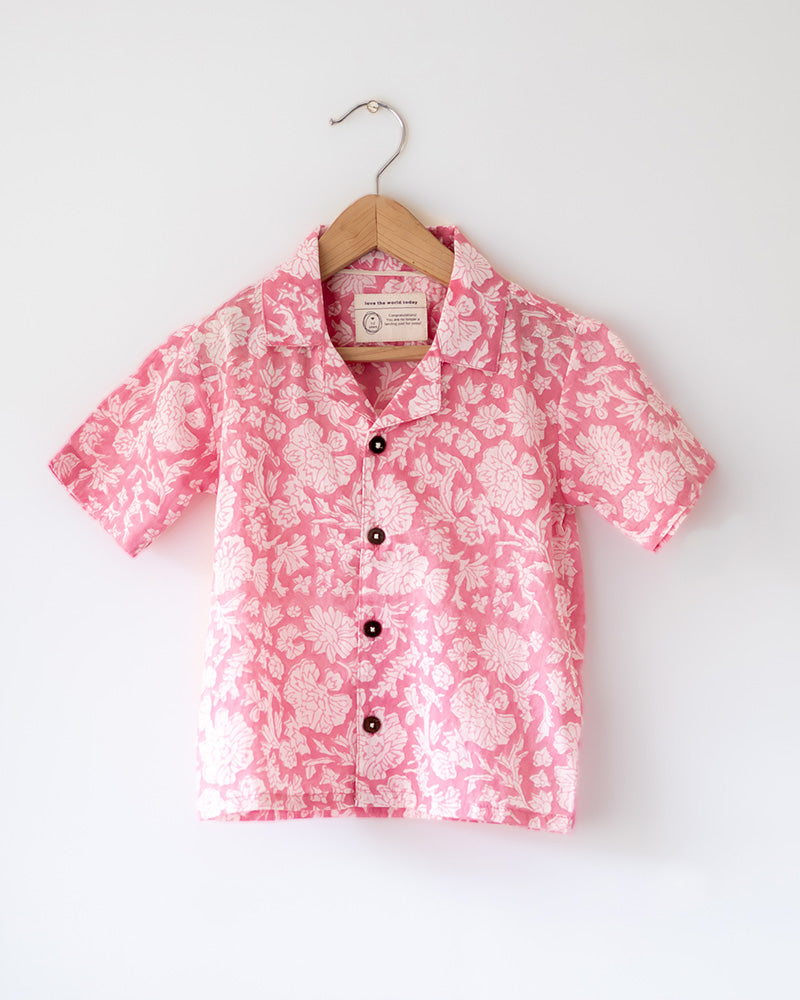Light pink floral loose fit relaxed mul mul shirt for boys with a stylish cuban collar and natural coconut shell buttons made by handblock print artisans in Jaipur, Rajasthan.