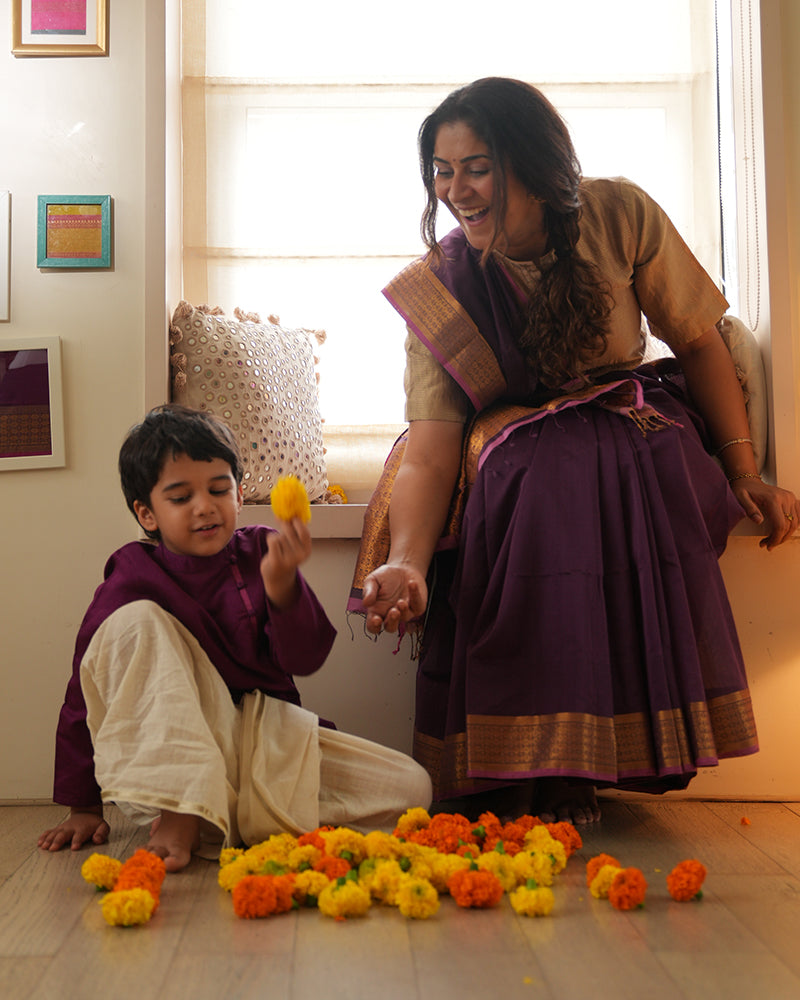 A Boy wearing a deep purple violet Indian festive Kurta with side buttons made with Handwoven cotton silk fabric woven by artisans in Maheshwar Madhya Pradesh. Mom and son celebrating diwali. Mother & Son love. Mom Son Duo.