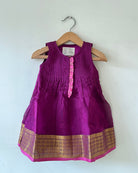 A deep purple violet sleeveless flared dress for infants in handwoven cotton silk by artisans in Maheshwar Madhya Pradesh. Perfect for festivities like Navratri, diwali, Dussehra, dushehra, bhai dooj. Infant wear. Baby ethnic wear. Silkwear for babies. Baby girl festive wear. 