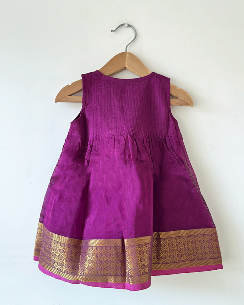 A deep purple violet sleeveless flared dress for infants in handwoven cotton silk by artisans in Maheshwar Madhya Pradesh. Perfect for festivities like Navratri, diwali, Dussehra, dushehra, bhai dooj. Infant wear. Baby ethnic wear. Silkwear for babies. Baby girl festive wear. 