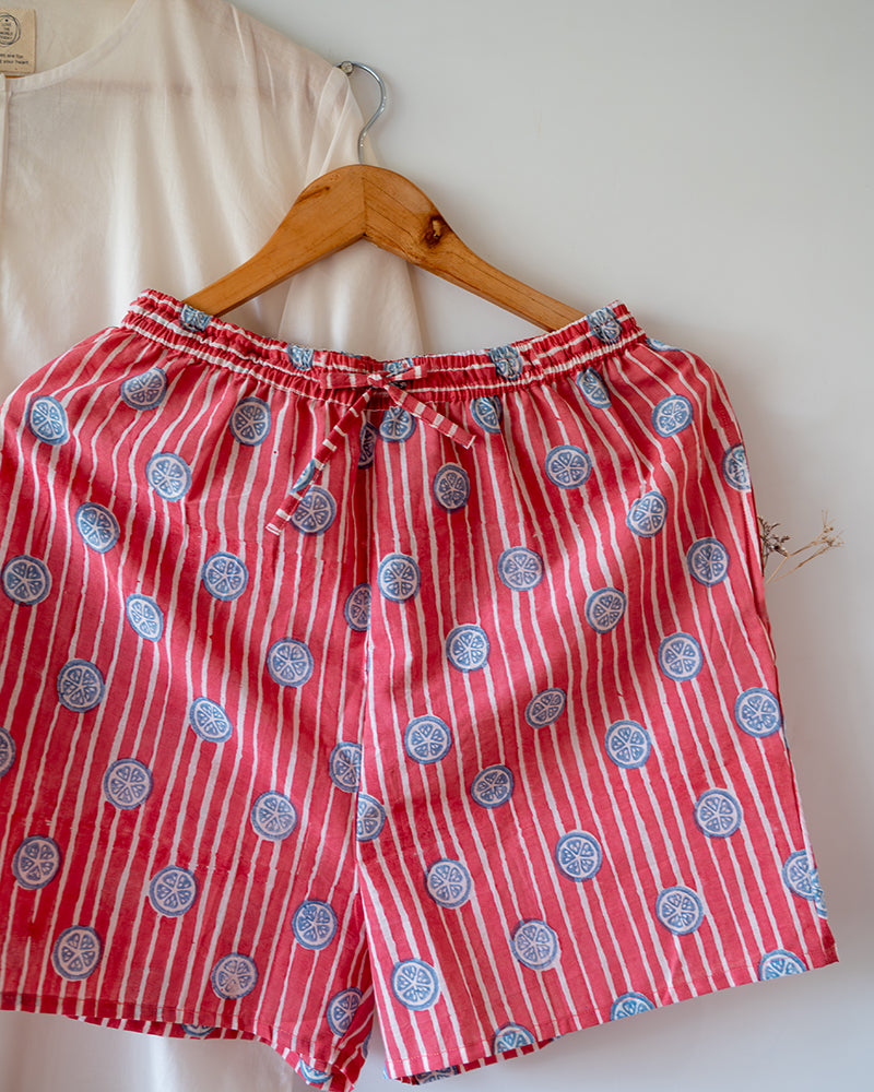 Unisex white cotton kurta and red shorts co ord set. 100% Cotton striped Shorts hand block printed by artisans in Jaipur, Rajasthan. Kurta made in GOTS certified organic cotton, has pockets and natural shell buttons. Shorts have soft elastication & drawstring at waist for ease of wear.