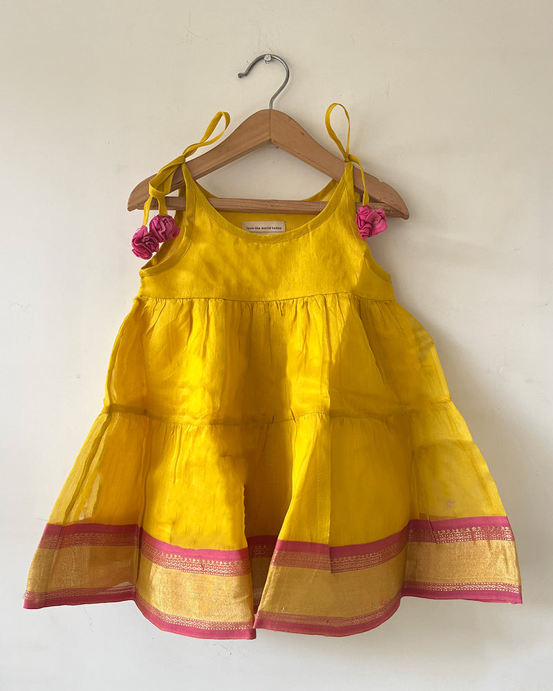 A bright yellow & pink sleeveless tiered dress for infants in handwoven cotton silk by artisans in Maheshwar Madhya Pradesh. Perfect for festivities like Navratri, diwali, Dussehra, dushehra, bhai dooj. Infant wear. Baby ethnic wear. Silkwear for babies. Baby girl festive wear. 