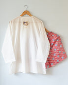 Unisex adults white cotton kurta and red shorts co ord set. 100% Cotton striped Shorts hand block printed by artisans in Jaipur, Rajasthan. Kurta made in GOTS certified organic cotton, has pockets and natural shell buttons.