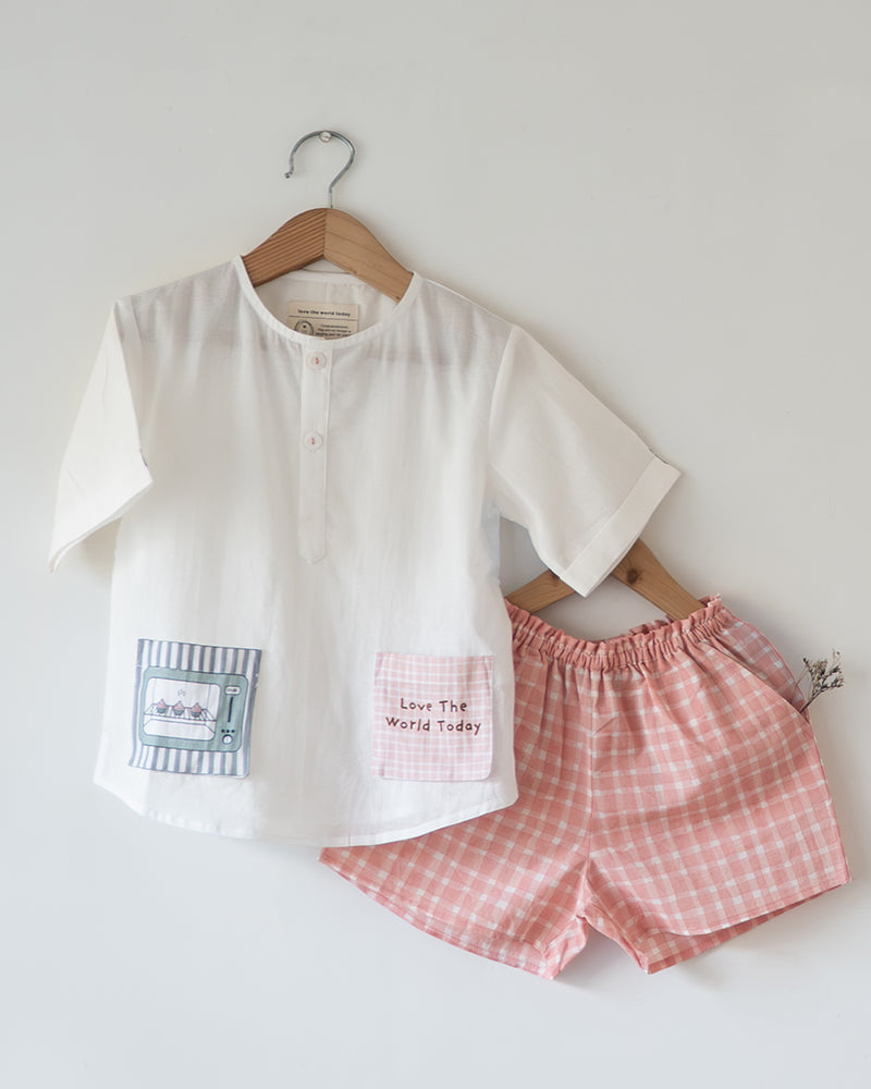 Unisex kids GOTS certified organic cotton white kurta and cotton peach shorts co ord set. 100% Cotton checkered Shorts hand block printed by artisans in Jaipur, Rajasthan. Kurta has pockets printed by hand block print. Shorts have soft elastication at waist for ease of wear.