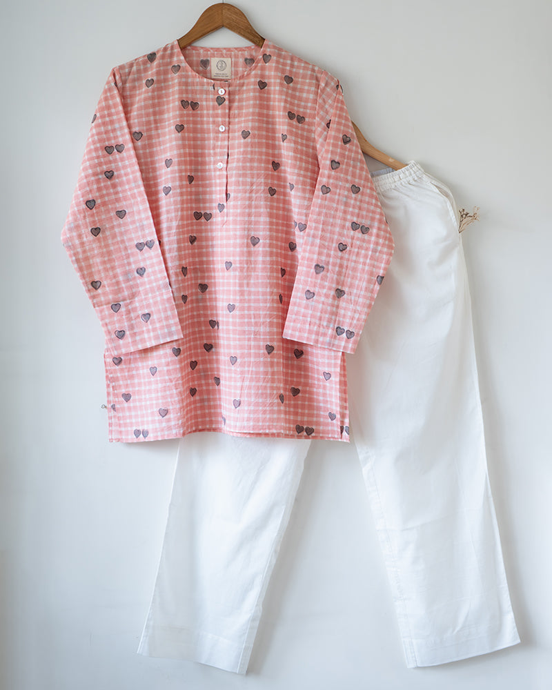 Unisex adults GOTS certified organic cotton pajama paired with peach checkered hand block printed kurta with pockets and natural shell buttons. Pajama has elastication at waist for ease of wear. Grandpa style kurta pajama set.
