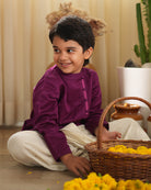 A Boy wearing a deep purple violet Indian festive Kurta with side buttons made with Handwoven cotton silk fabric woven by artisans in Maheshwar Madhya Pradesh. This kids ethnic kurta is best for upcoming festivities like kids Navratri outfit, kids durga pooja kurta, Dussehra, dushehra, ethnic dress for Diwali, bhai dooj and kids/ boys kurta for weddings. Kid celebrating diwali.