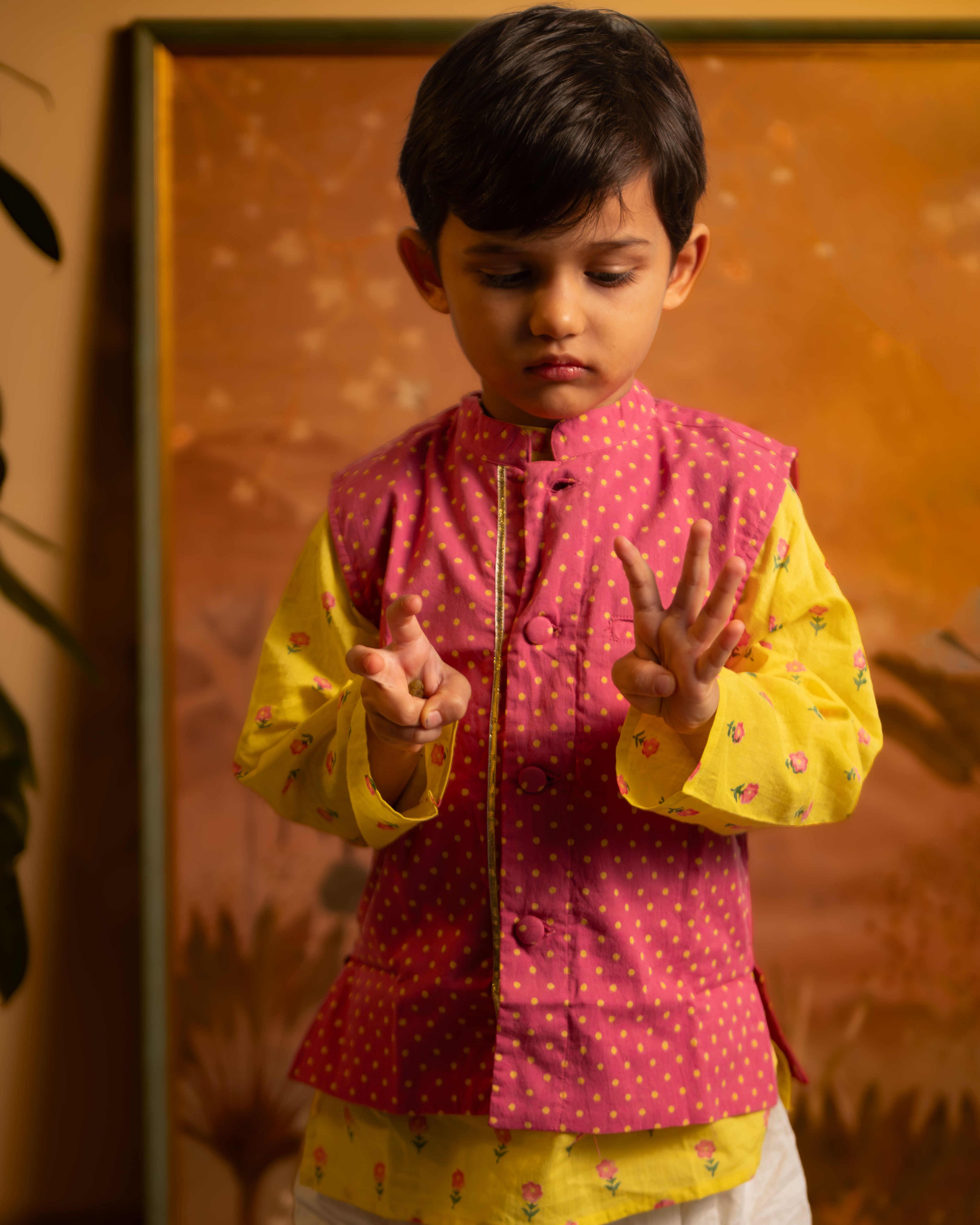 Bright magenta pink Polka dot cotton bandi nehru jacket with self potli buttons and a golden selvedge.
