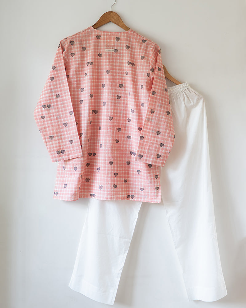 Unisex adults GOTS certified organic cotton pajama paired with peach checkered hand block printed kurta with pockets and natural shell buttons. Pajama has elastication at waist for ease of wear. Grandpa style kurta pajama set.