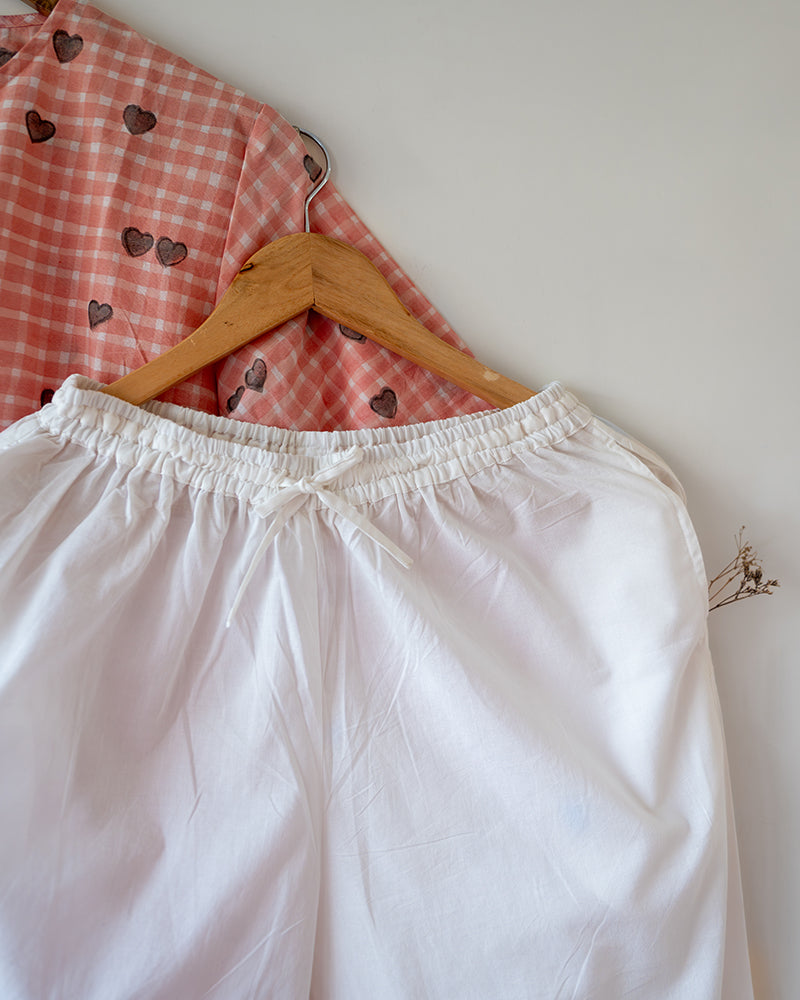 Unisex adults GOTS certified organic cotton pajama paired with peach checkered hand block printed kurta with pockets and natural shell buttons. Pajama has elastication at waist for ease of wear. Grandpa style kurta pajama set.