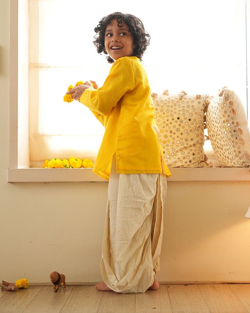 A Boy wearing a bright yellow Indian festive Kurta with side buttons made with Handwoven cotton silk fabric woven by artisans in Maheshwar Madhya Pradesh.