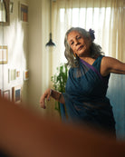 A woman wearing a deep teal blue colored cotton silk saree with golden checks handwoven by weavers in Maheshwar, Madhya Pradesh. This Maheshwari Cotton silk saree is perfect for festivities like Navratri, durga pooja, Dussehra, dushehra, diwali pooja, bhai dooj and weddings. Women's silk wear, silk saree for women, cotton silk saree, heavy pallu border sarees. 