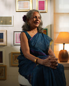 A woman wearing a deep teal blue colored cotton silk saree with golden checks handwoven by weavers in Maheshwar, Madhya Pradesh. This Maheshwari Cotton silk saree is perfect for festivities like Navratri, durga pooja, Dussehra, dushehra, diwali pooja, bhai dooj and weddings. Women's silk wear, silk saree for women, cotton silk saree, heavy pallu border sarees. 