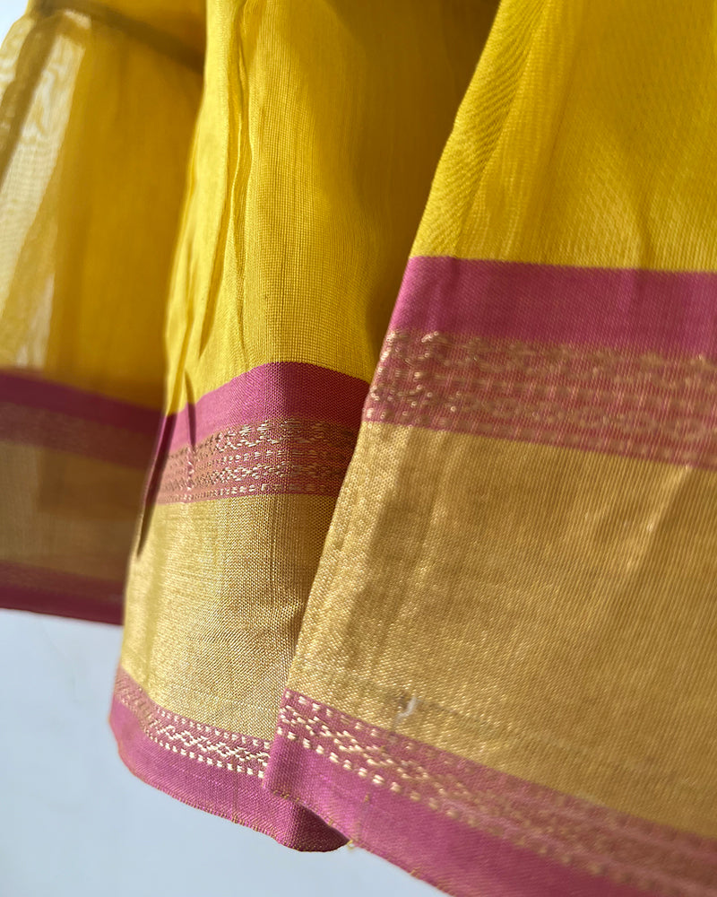 A bright yellow & pink sleeveless tiered dress for infants in handwoven cotton silk by artisans in Maheshwar Madhya Pradesh. Perfect for festivities like Navratri, diwali, Dussehra, dushehra, bhai dooj. Infant wear. Baby ethnic wear. Silkwear for babies. Baby girl festive wear.  border dress. 