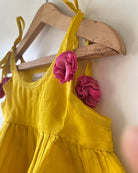 A bright yellow & pink sleeveless tiered dress for infants in handwoven cotton silk by artisans in Maheshwar Madhya Pradesh. Perfect for festivities like Navratri, diwali, Dussehra, dushehra, bhai dooj. Infant wear. Baby ethnic wear. Silkwear for babies. Baby girl festive wear.  Dress with tassels.