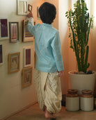 A Boy wearing a light baby blue Indian festive Kurta with golden polka dot motifs made with Handwoven cotton silk fabric woven by artisans in Maheshwar Madhya Pradesh. This kids ethnic kurta is best for upcoming festivities like kids Navratri outfit, kids durga pooja kurta, Dussehra, dushehra, ethnic dress for Diwali, bhai dooj and kids/ boys kurta for weddings. Paired with an off white dhoti/ mundu. Perfect Kids silk wear, ethnic wear for kids, festive clothing for kids.