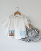 Unisex kids GOTS certified organic cotton white kurta and grey cotton shorts co ord set. 100% Cotton checkered Shorts hand block printed by artisans in Jaipur, Rajasthan. Kurta made in GOTS certified organic cotton, has pockets printed by hand block print. 