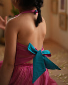 A girl wearing a cute pink and golden striped cotton silk coord set handwoven with silver polka dots by weavers in Maheshwar, Madhya Pradesh. Tie back top. 