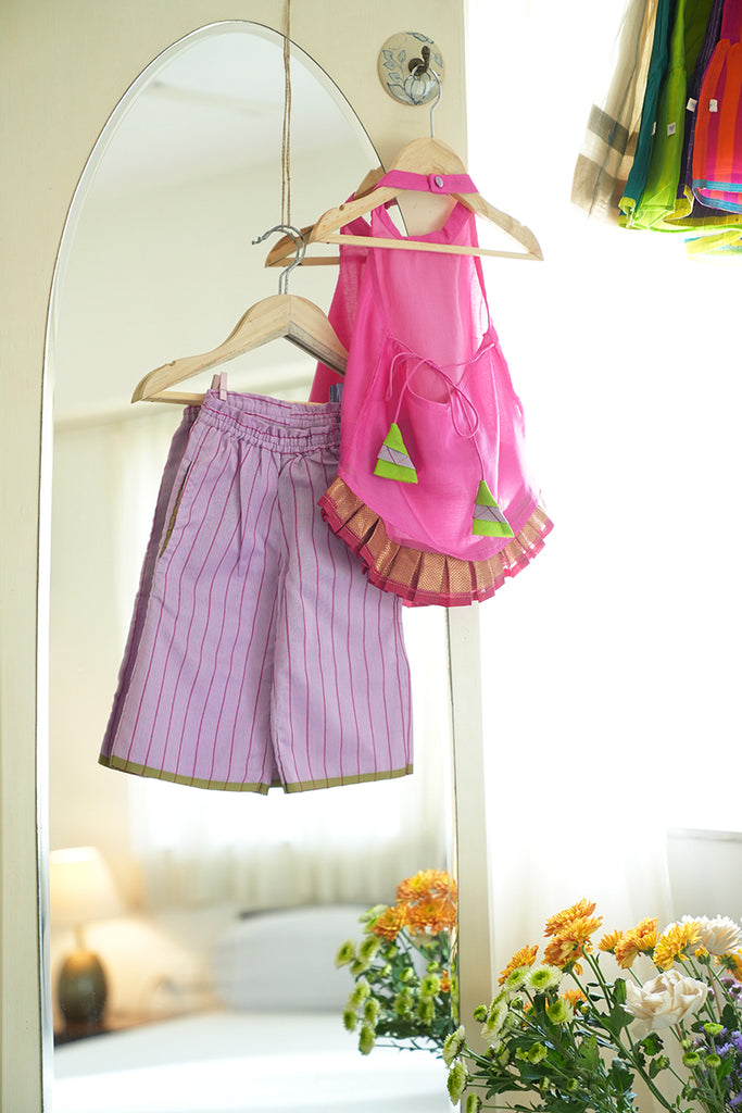 Girls indian wear outfit with a pink halter neck top with colourful tassels and purple sharara pant