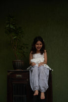 girl-dressed-in-unisex-kids-pants-in-grey-hand-block-print-cotton- fabric-from-jaipur-artisan-made-paired-with-a-white-handwoven-top
